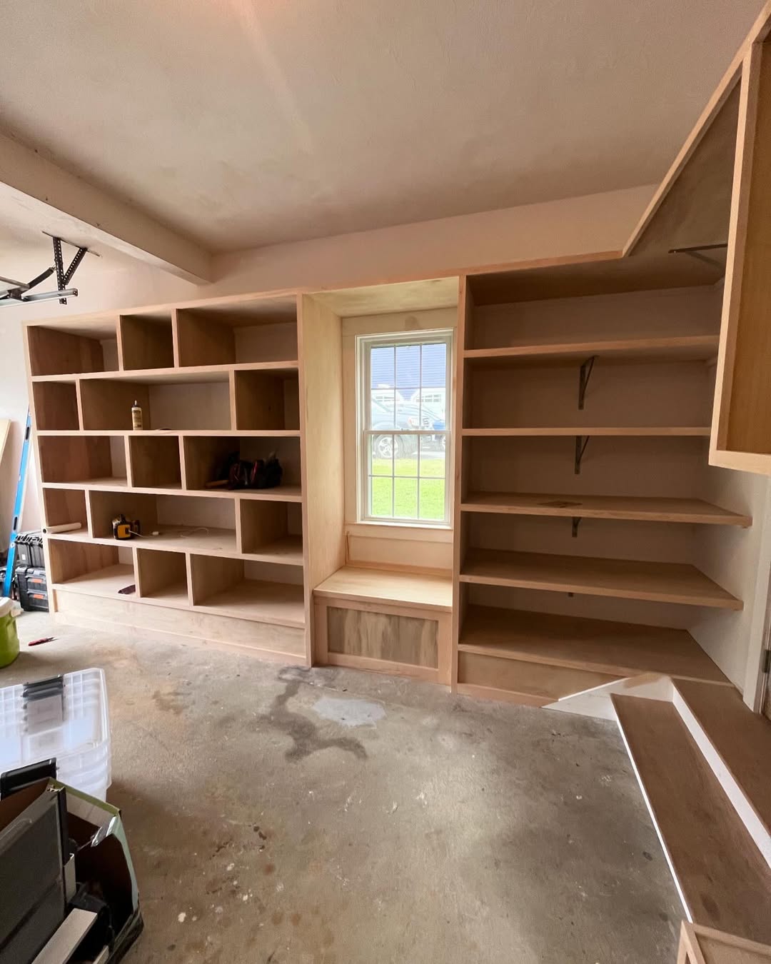 Floor-to-ceiling built-in cabinetry with window seat — framing stage